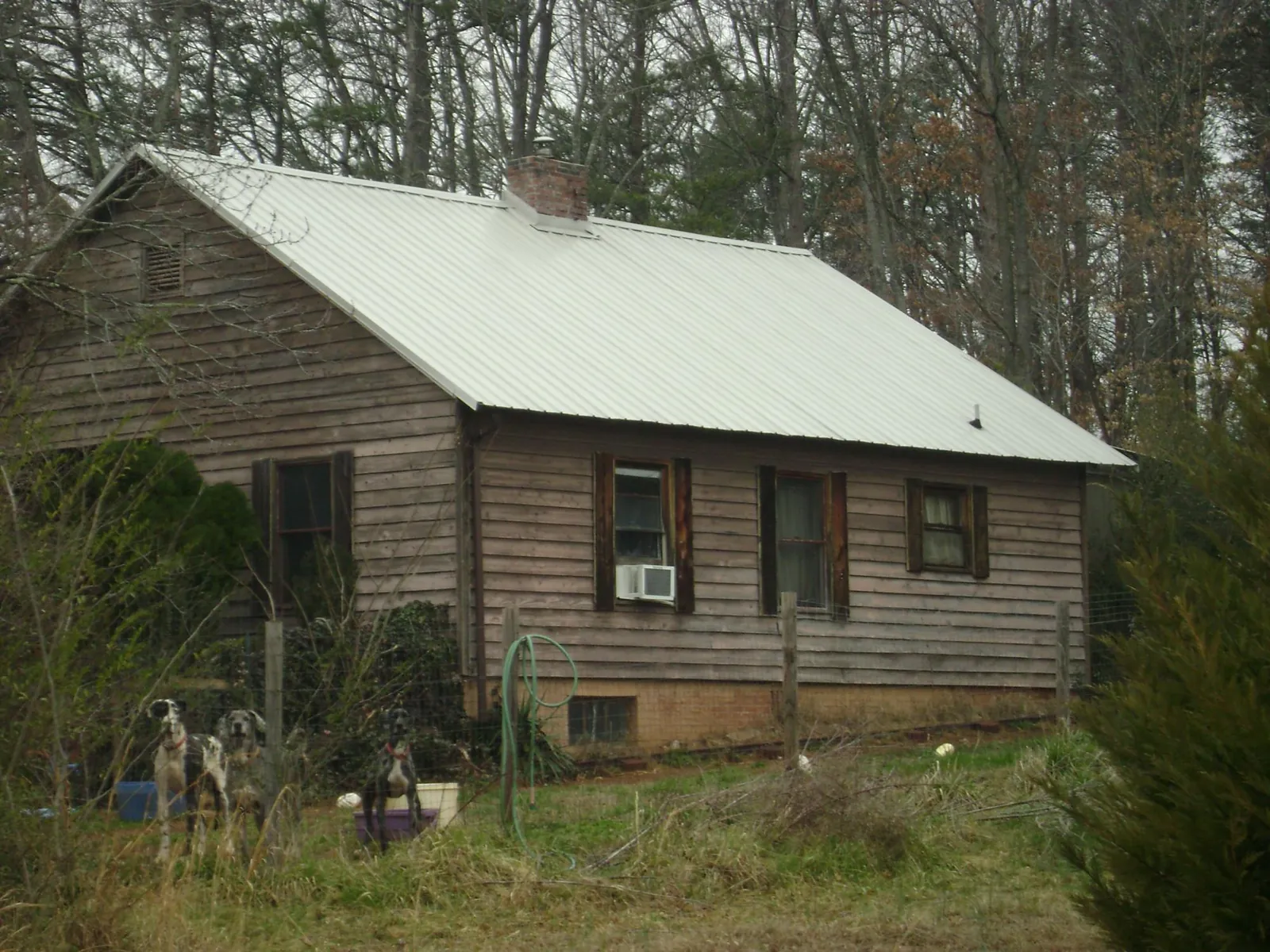 White metal roof on an old wood sided farmhouse, from a Metal Roof Installation job in Oelwein